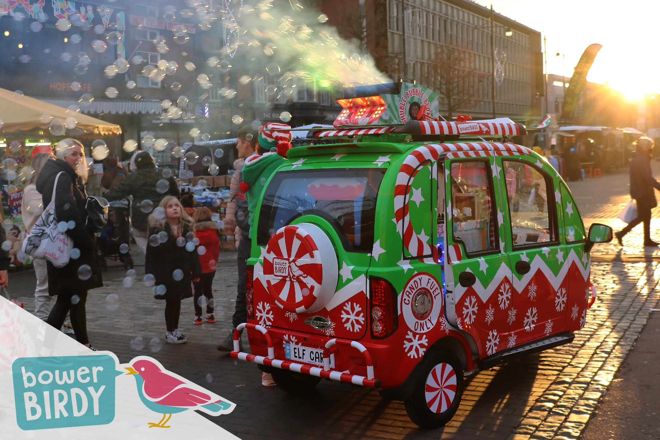 Elf Car Christmas Event: The Elf Car blasts out bubbles in the sunset at Romford Market