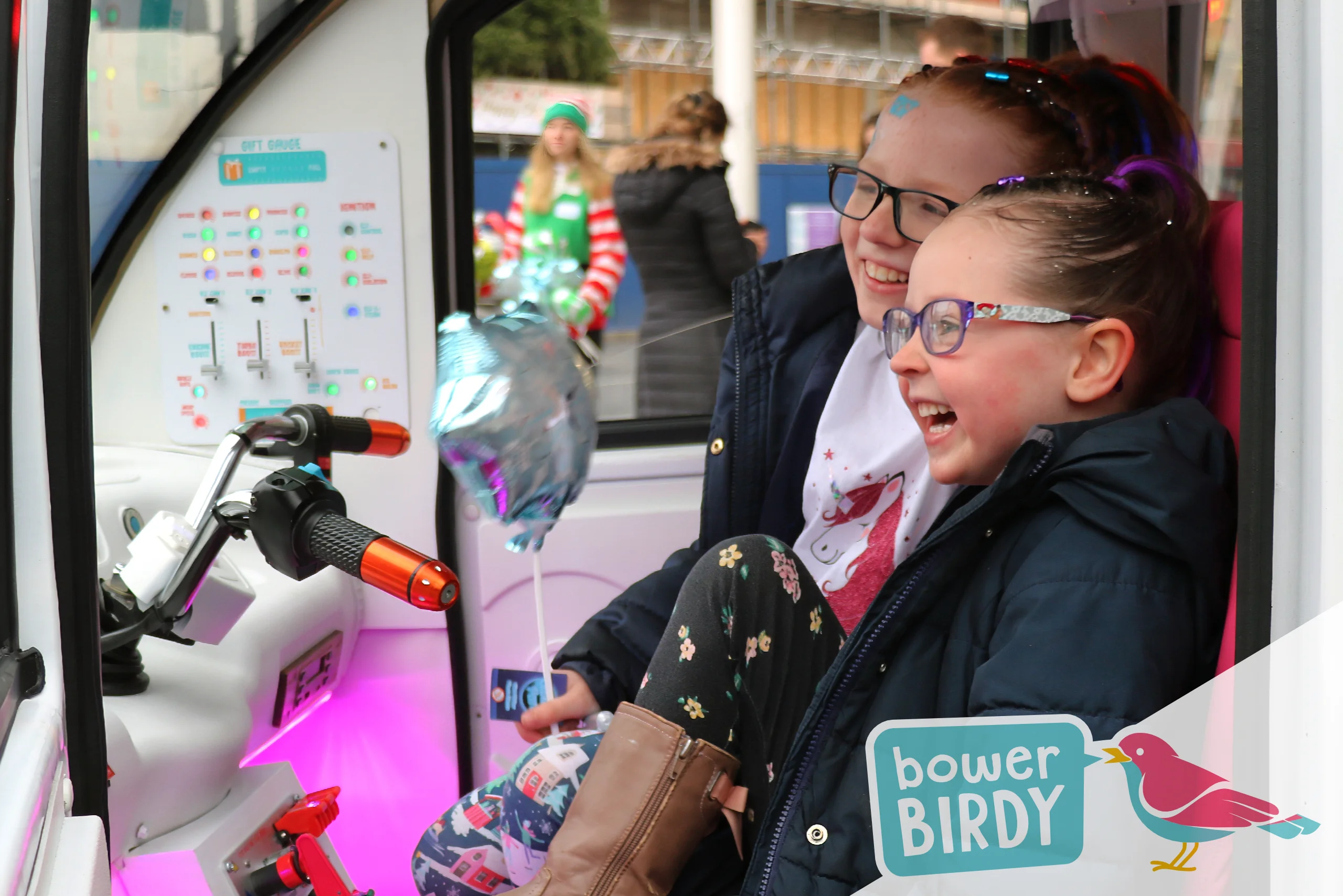 Christmas Fun with the Magical Elf Car: Two sisters sit inside the Elf Car laughing at Santa during a video call