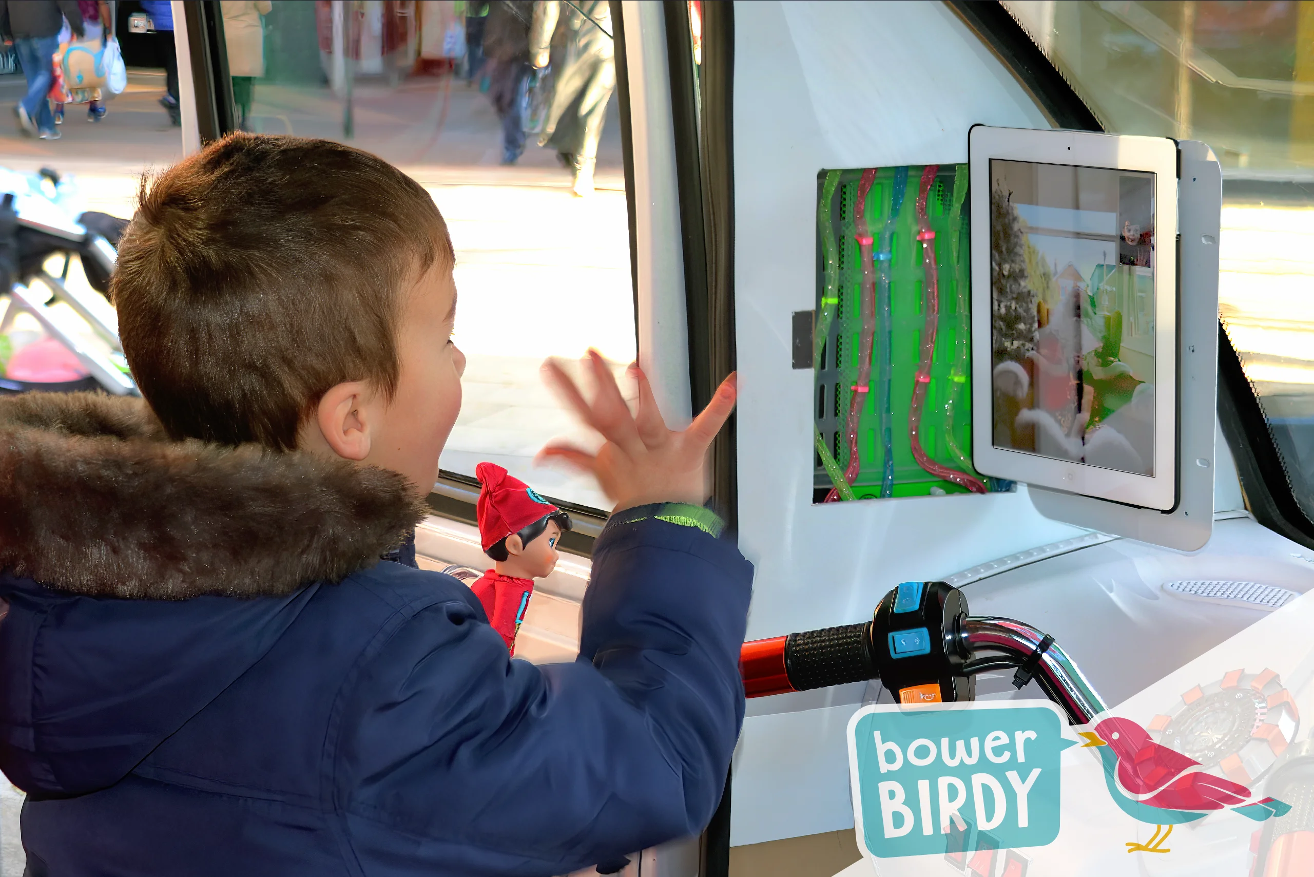 Elf Car Christmas Magic in Stevenage: A young boy waves to Father Christmas via video call, in the front seat of the Elf Car