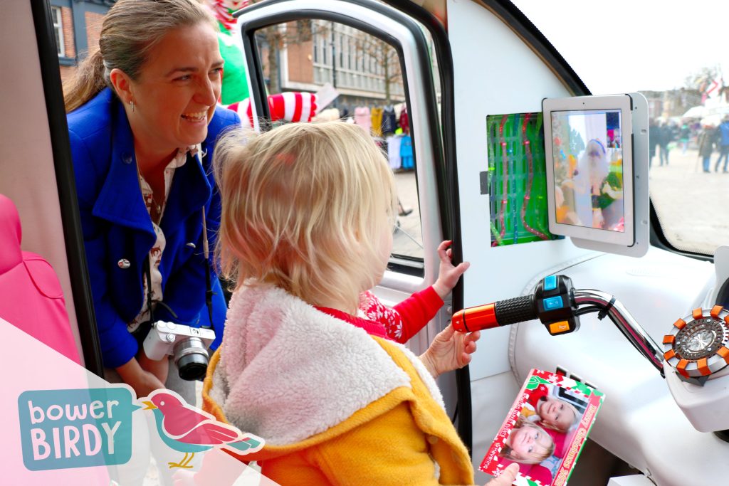 Magical Elf Car Christmas Event: Young children sitting in the passenger seat of the Elf Car talking to Father Christmas on a video call.