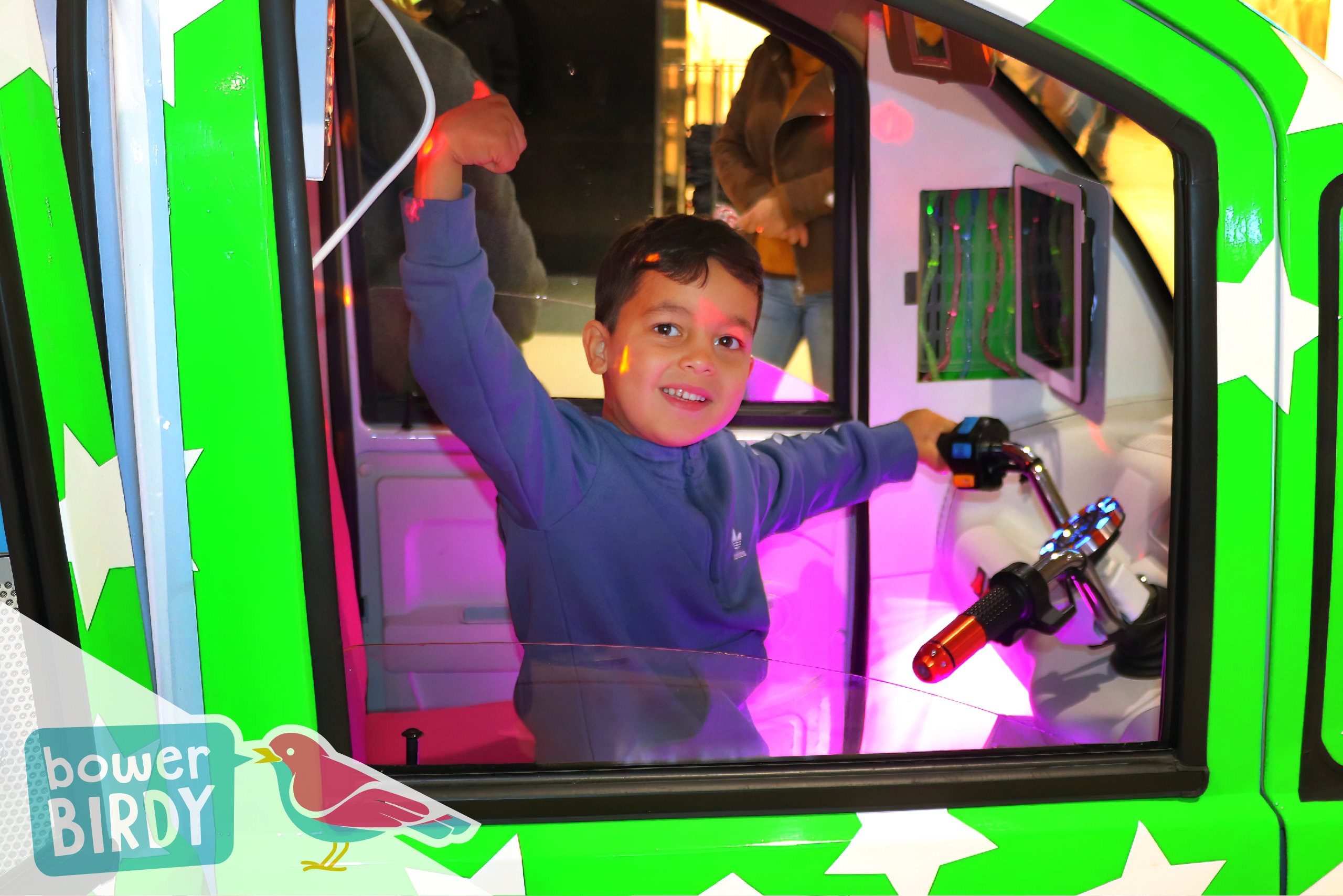 A boy gives a thumb up from the front seat of the Elf Car
